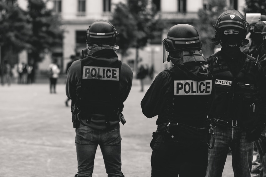 Armed and geared police officers watching developing riot